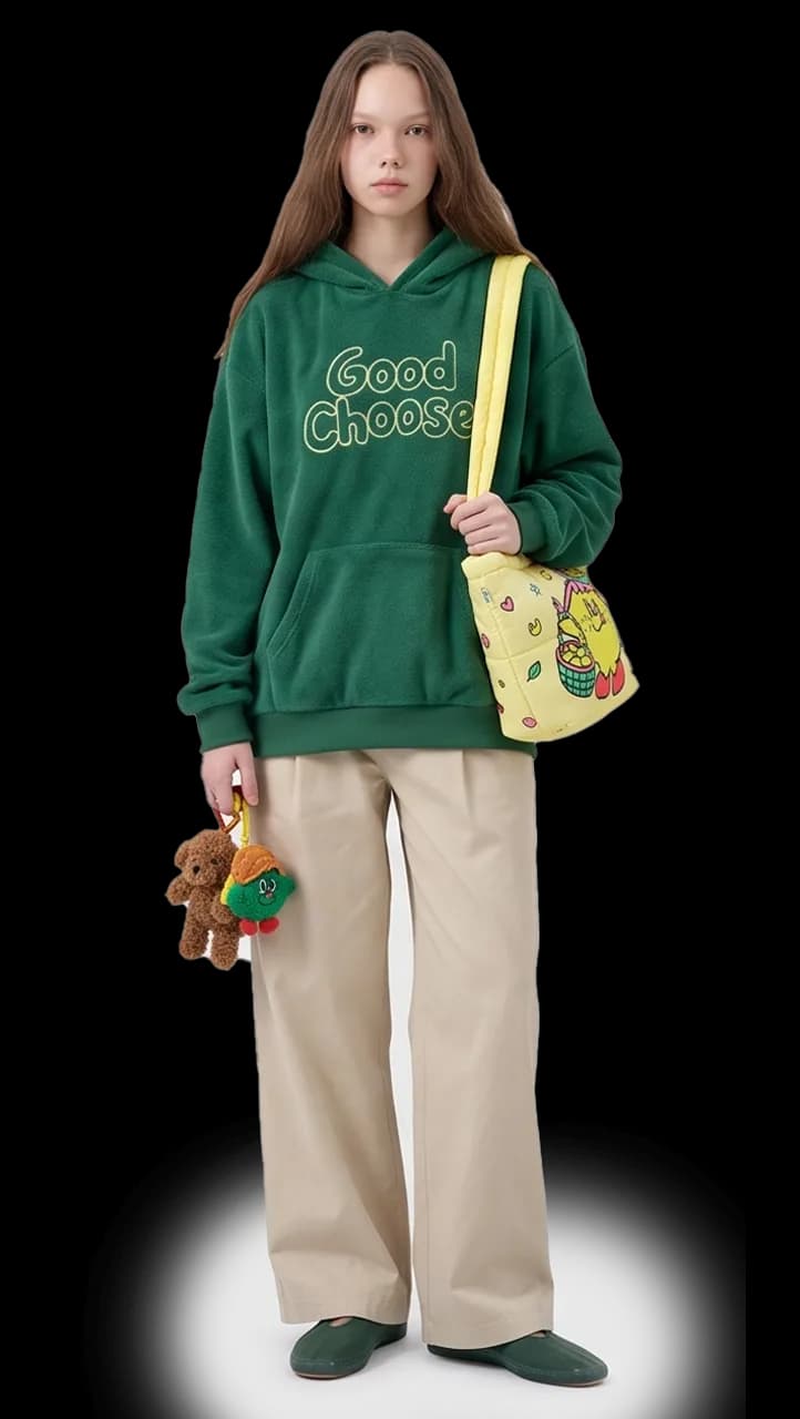Model in a green Good Choose fleece hoodie with a yellow shoulder bag